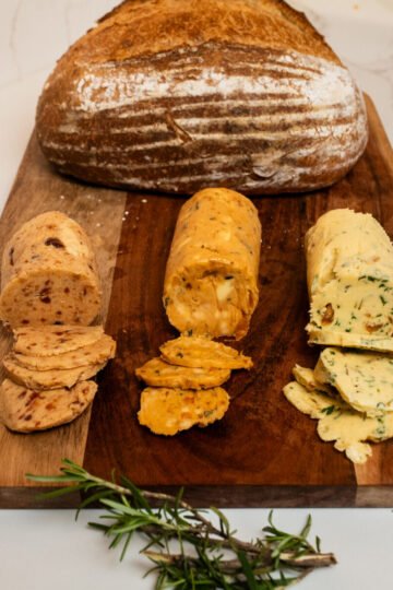 Three compound butter logs on parchment: Sun-Dried Tomato, Vanilla Guava, and Garlic Herb.