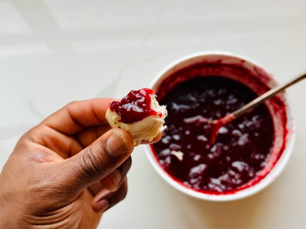 Host Thanksgiving with less stress - overhead hand holding turkey with cranberry sauce on it