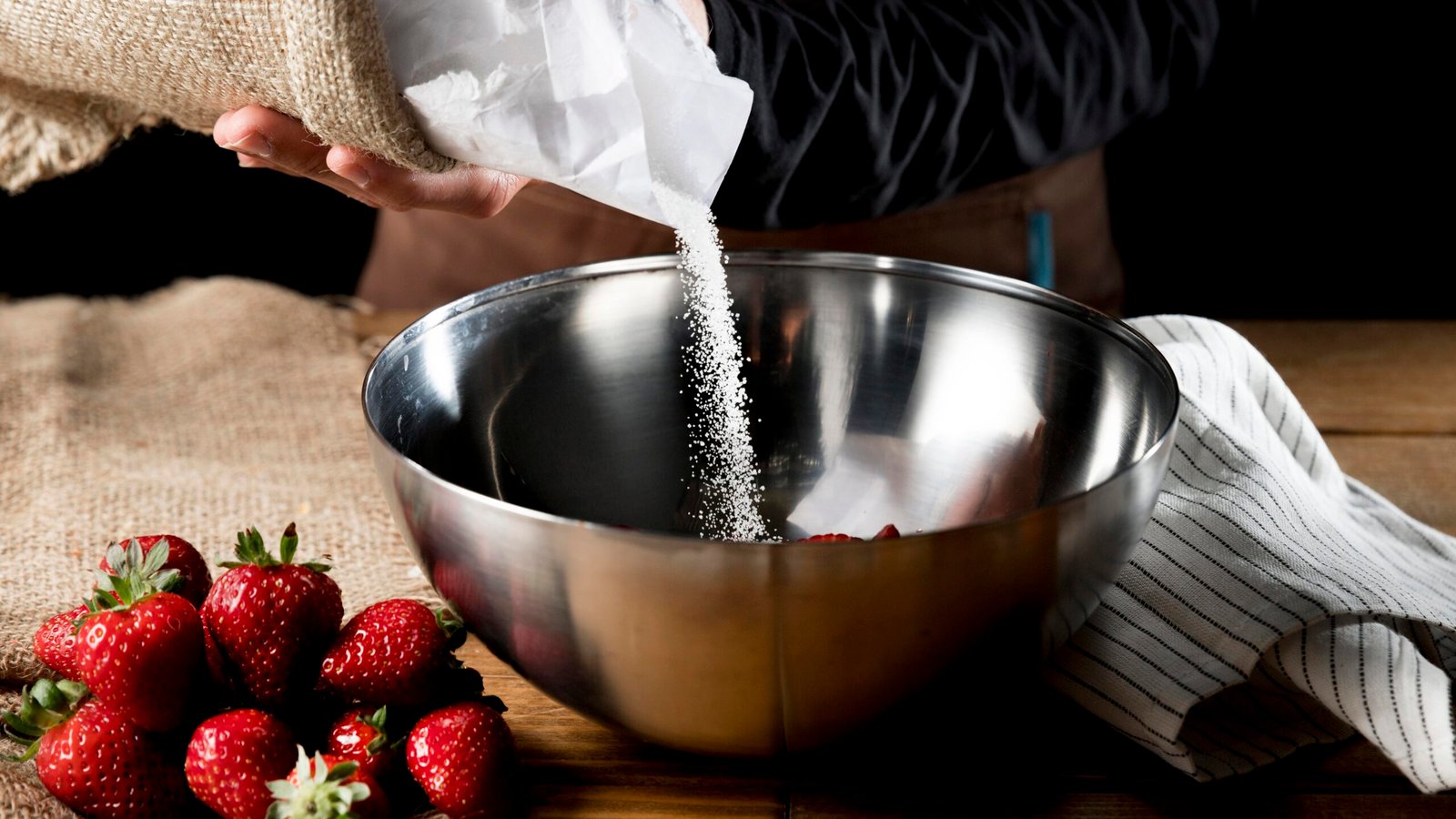 cook-adding-sugar-bowl-with-strawberries