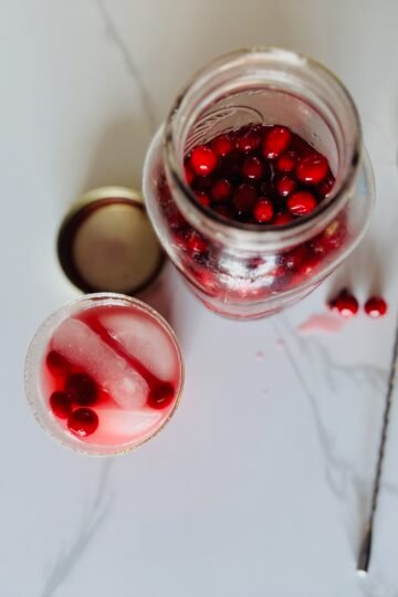 overhead shot of Cranberry Mocktail with a jar of pickled cranberries