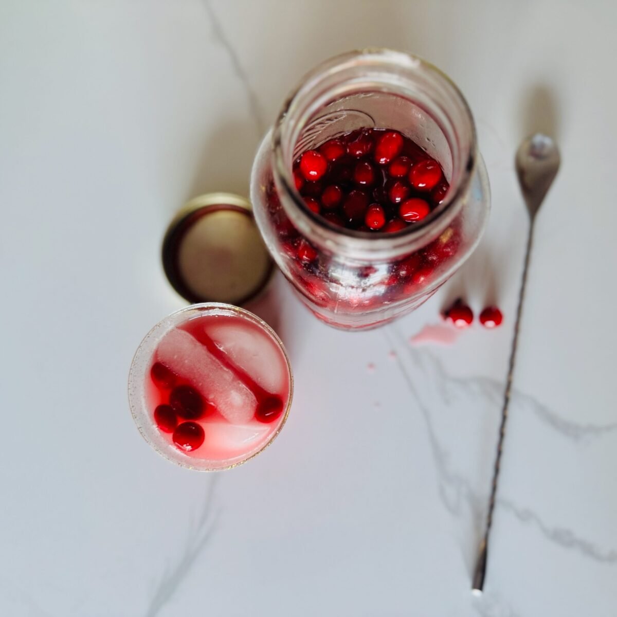 overhead shot of Cranberry Mocktail with a jar of pickled cranberries