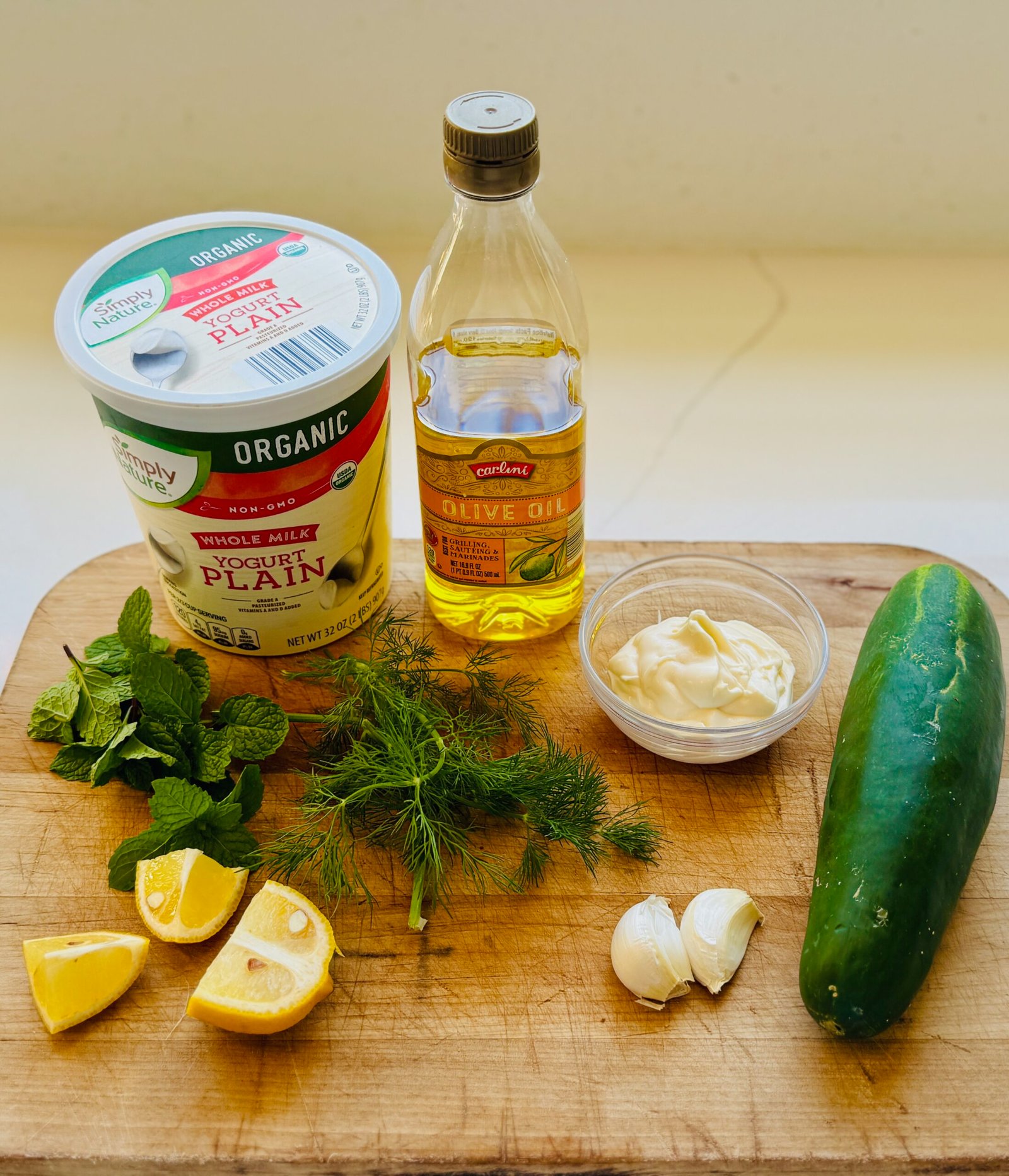 Fresh tzatziki ingredients including yogurt cucumber garlic mint dill and lemon