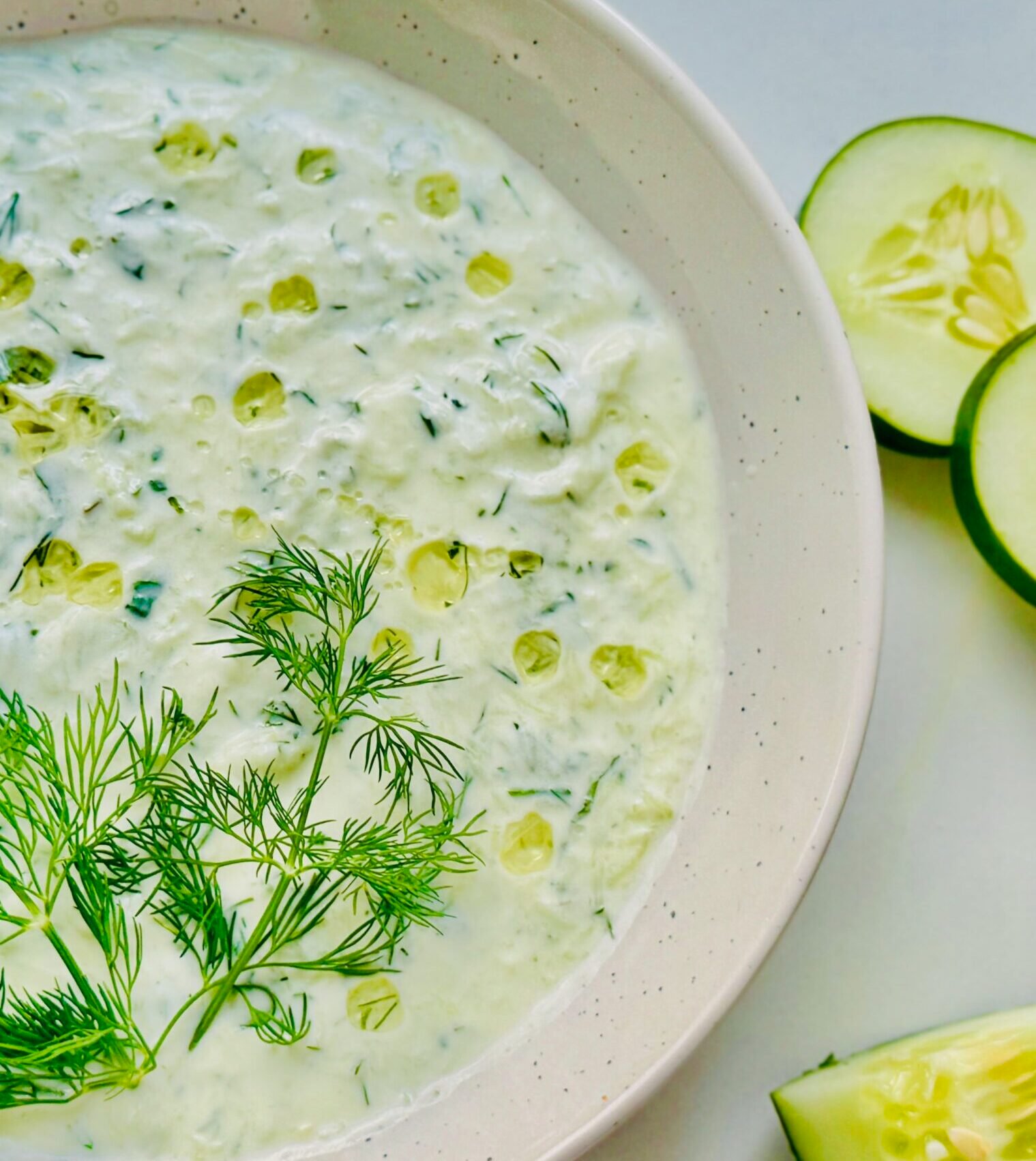 Creamy homemade tzatziki sauce topped with fresh mint and dill