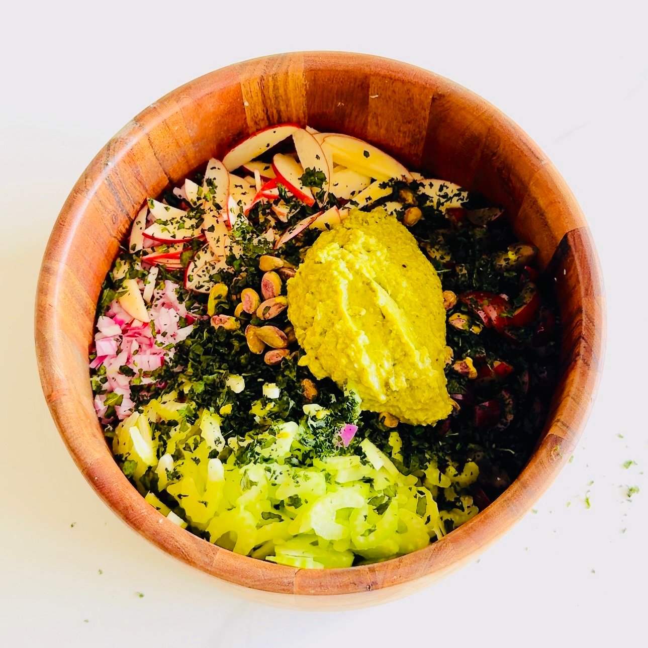 Rotisserie chicken salad with grapes apples pistachios and green sauce in a serving bowl