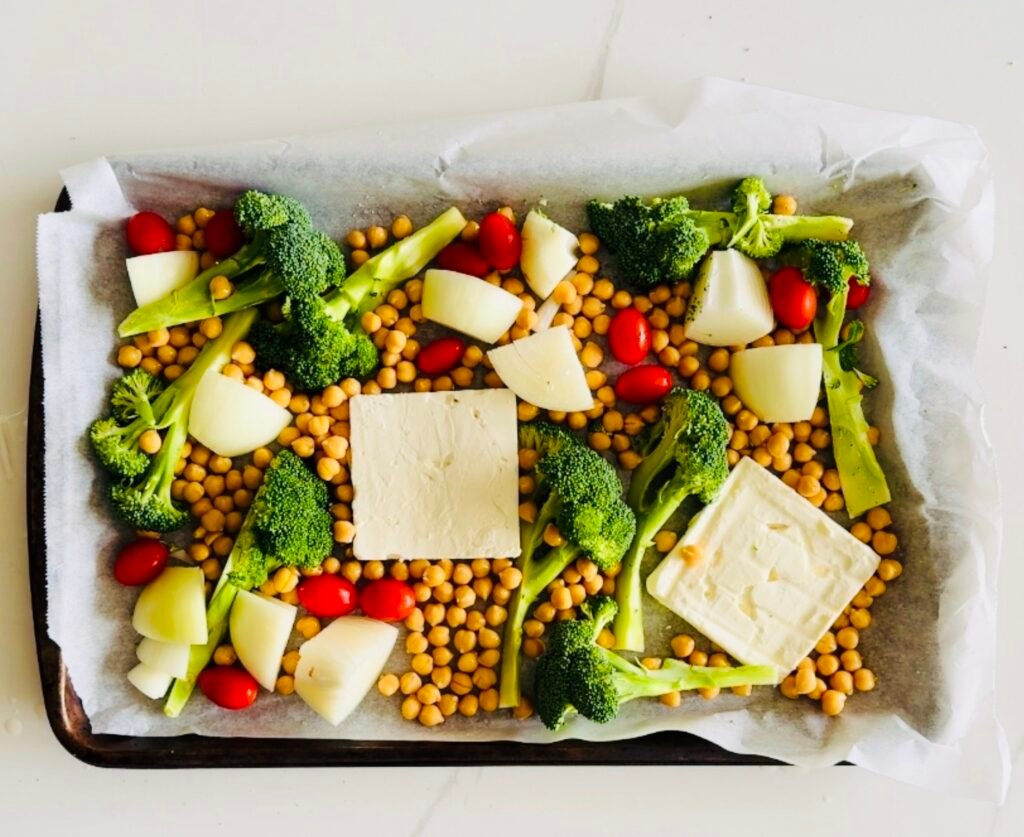 sheet pan with baked feta broccoli tomatoes onions and chickpeas seasoned with za’atar