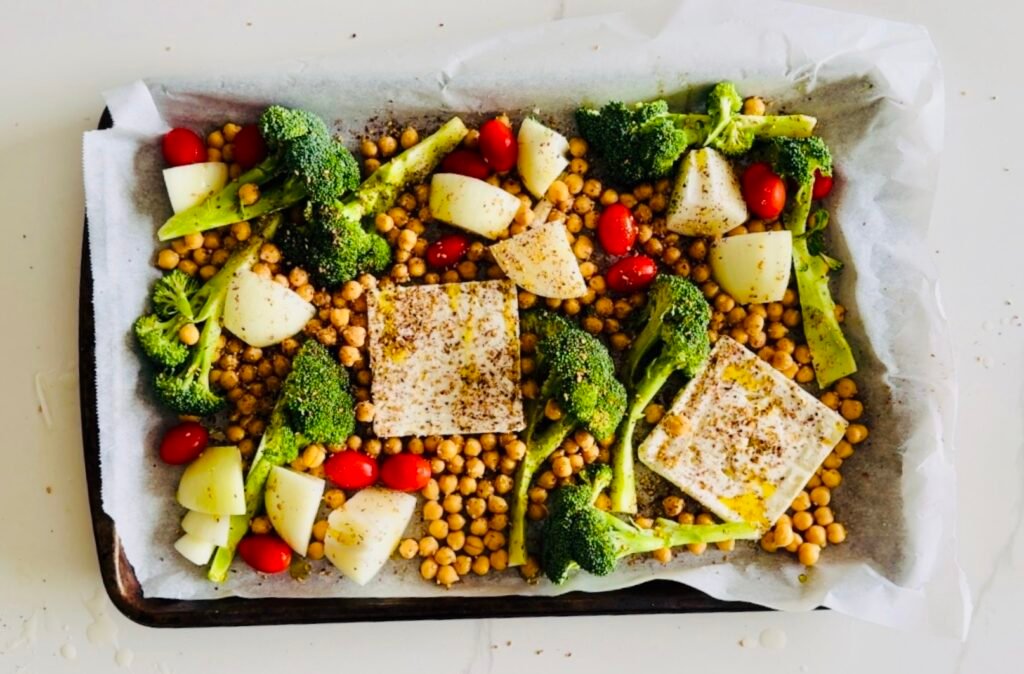 sheet pan with baked feta broccoli tomatoes onions and chickpeas seasoned with za’atar