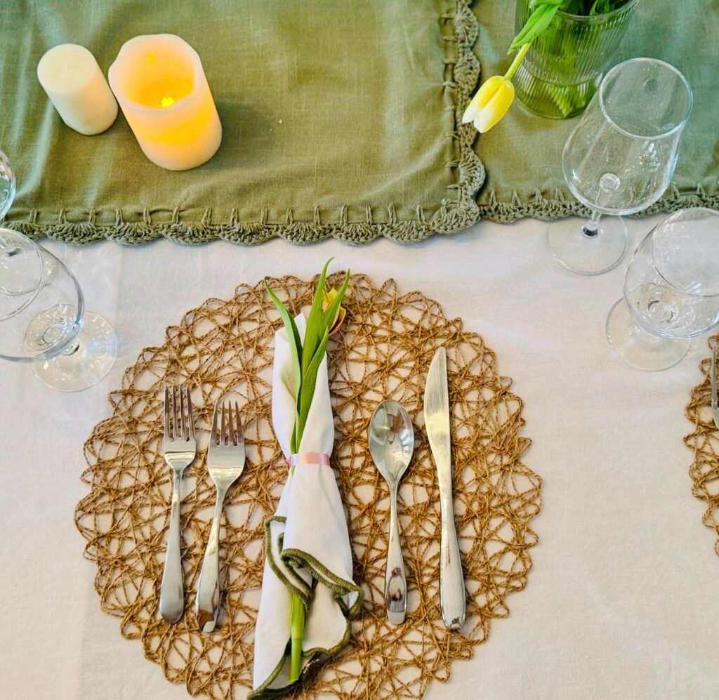 Spring 7 course dinner party table with white linens, green runner, woven placemats, and fresh tulips