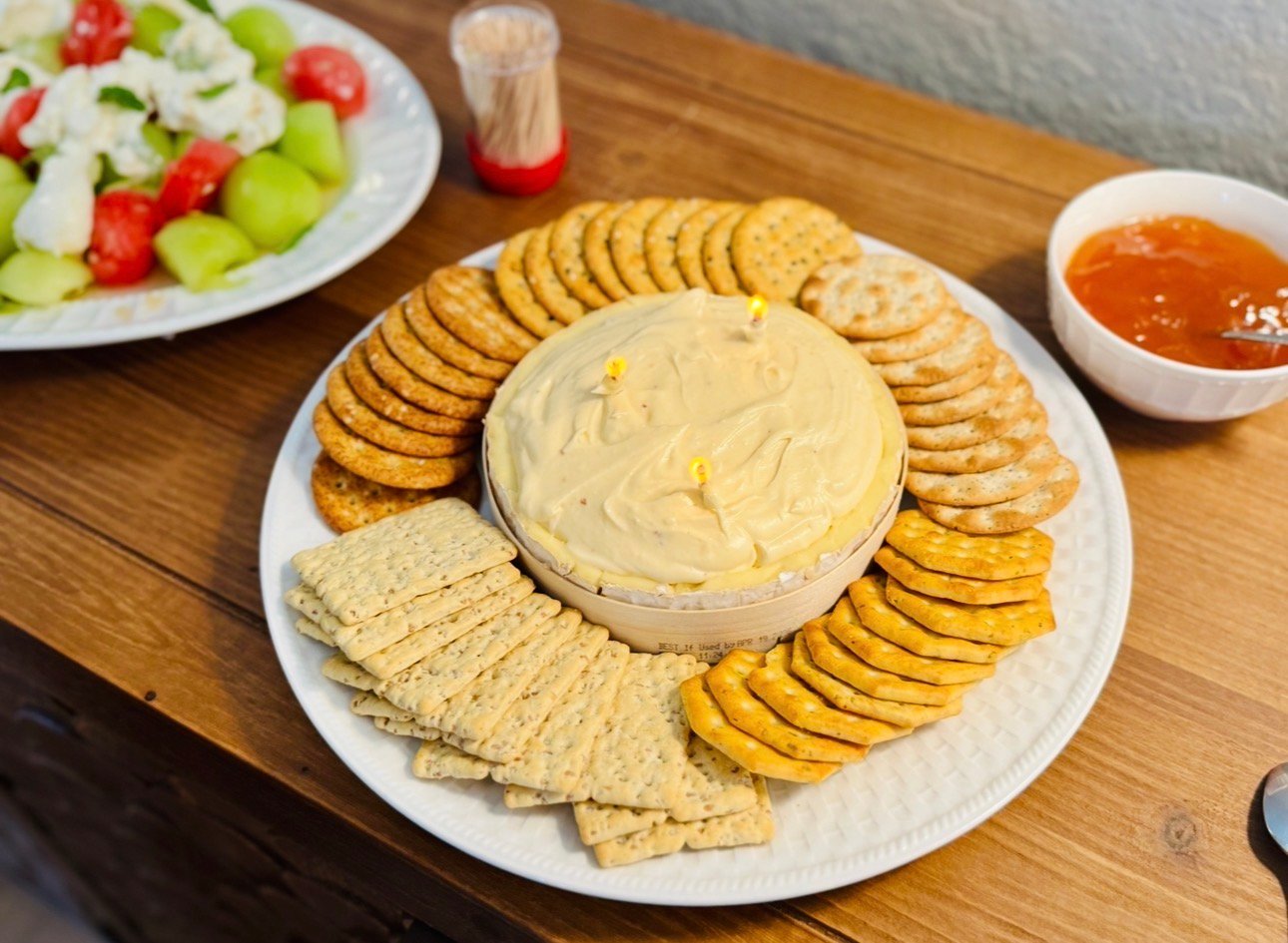 Brie butter candle served with apricot jam and crackers for a spring dinner party