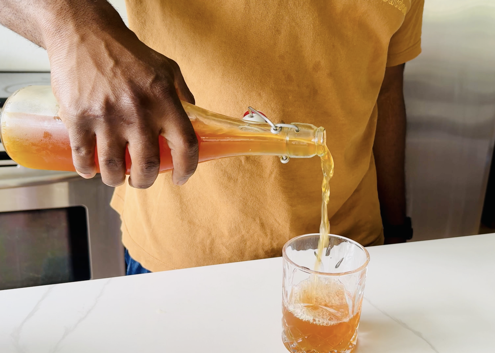 Homemade Kombucha being pour in glass cup