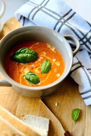 Roasted Tomato Soup with fresh basil in a bowl with bread
