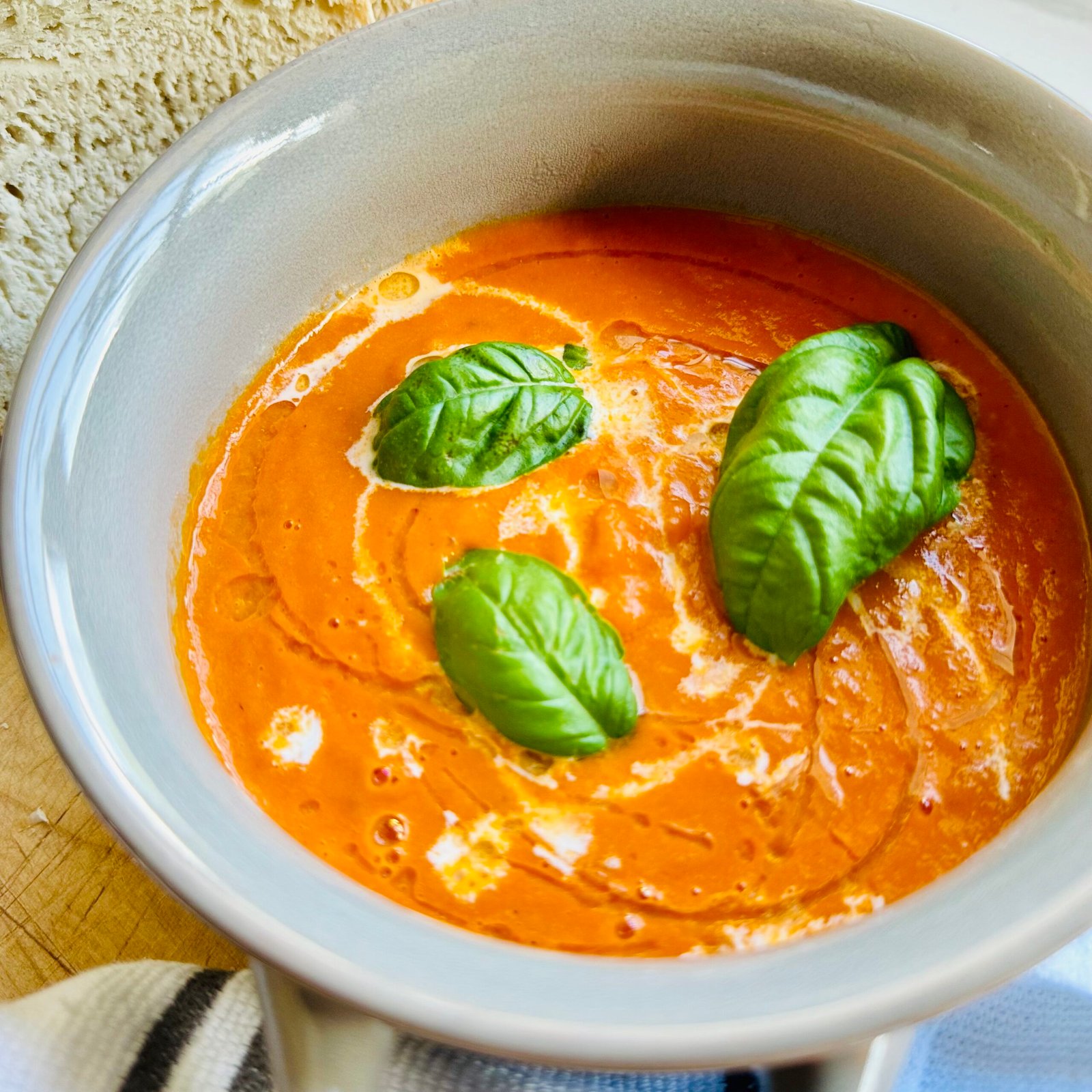 Roasted Tomato Soup with fresh basil in a bowl with bread