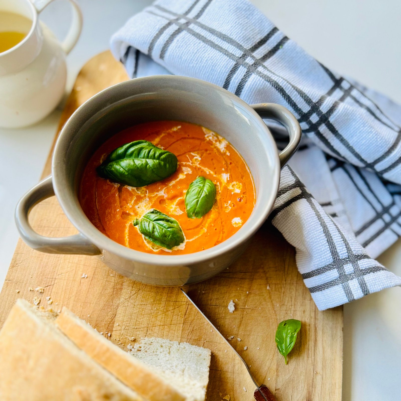 Roasted Tomato Soup with fresh basil in a bowl with bread