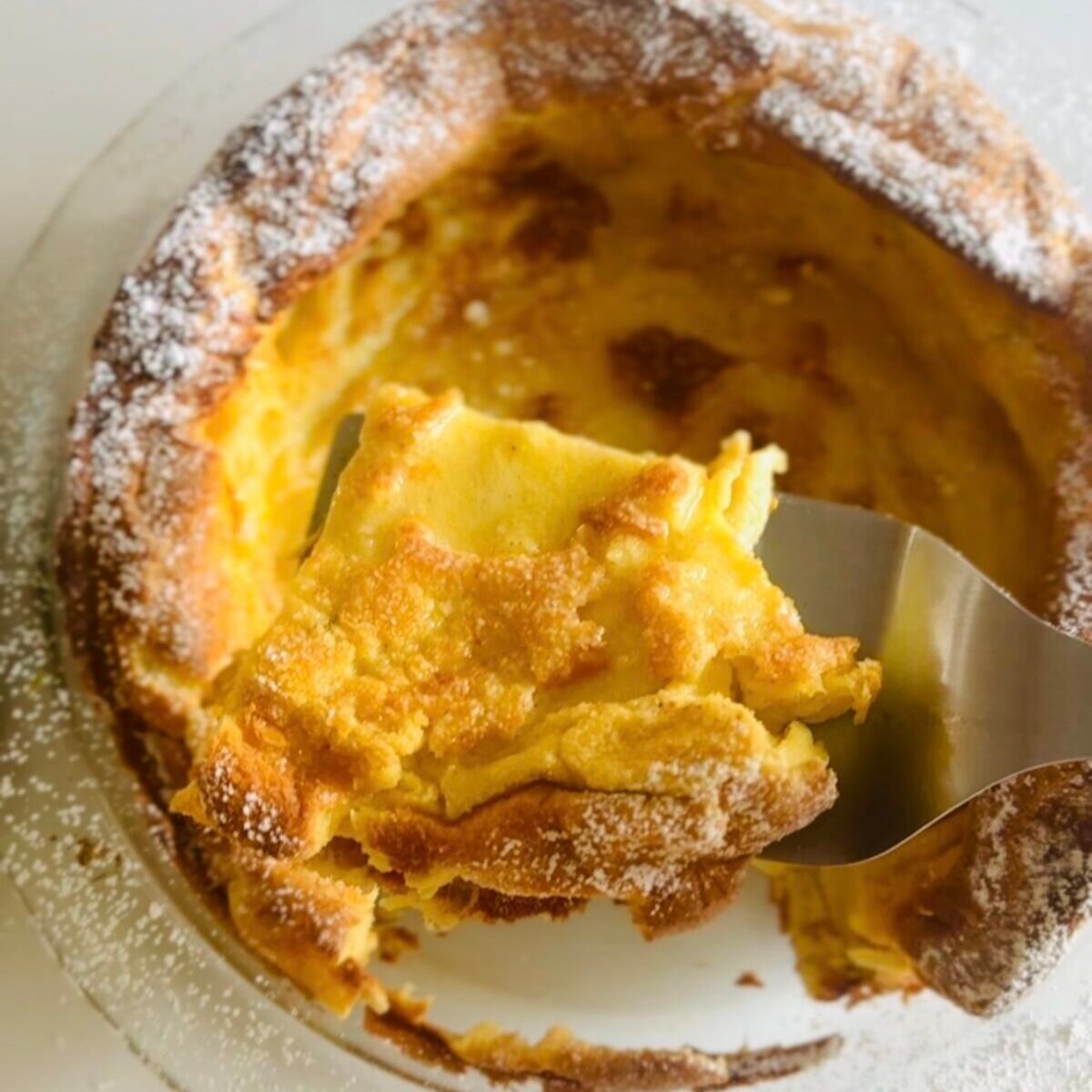  Easy German pancakes puffed and golden in a baking dish with powdered sugar 