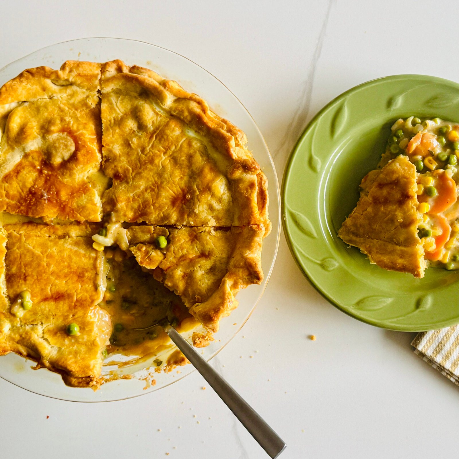  Slice of creamy vegetable pot pie with sweet potatoes, corn, peas, carrots, celery, and golden crust