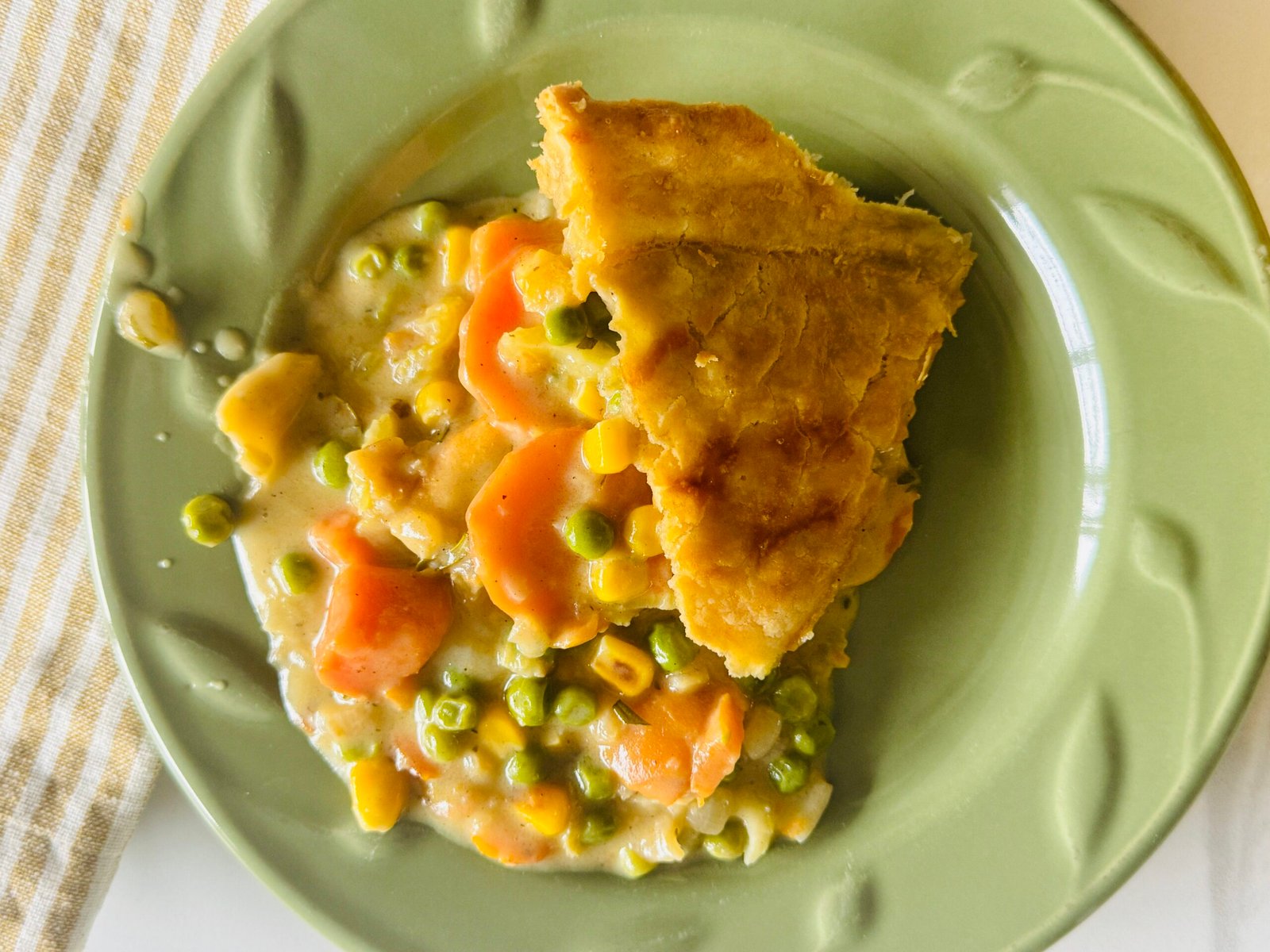 Vegetable pot pie topped with golden pie crust and fresh rosemary after baking
