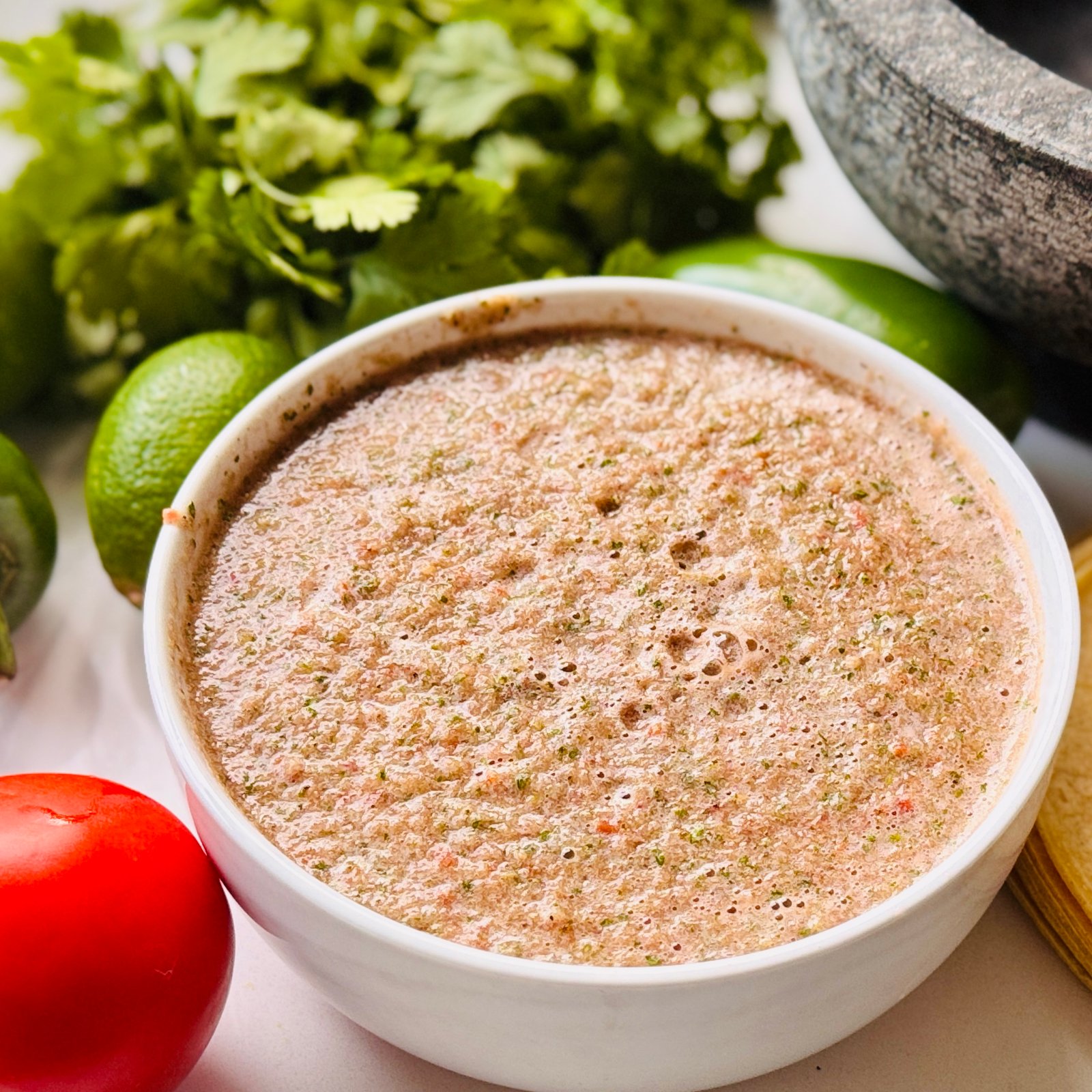 Blender salsa with fresh tomatoes jalapeño cilantro lime onion and honey blended into a loose red salsa