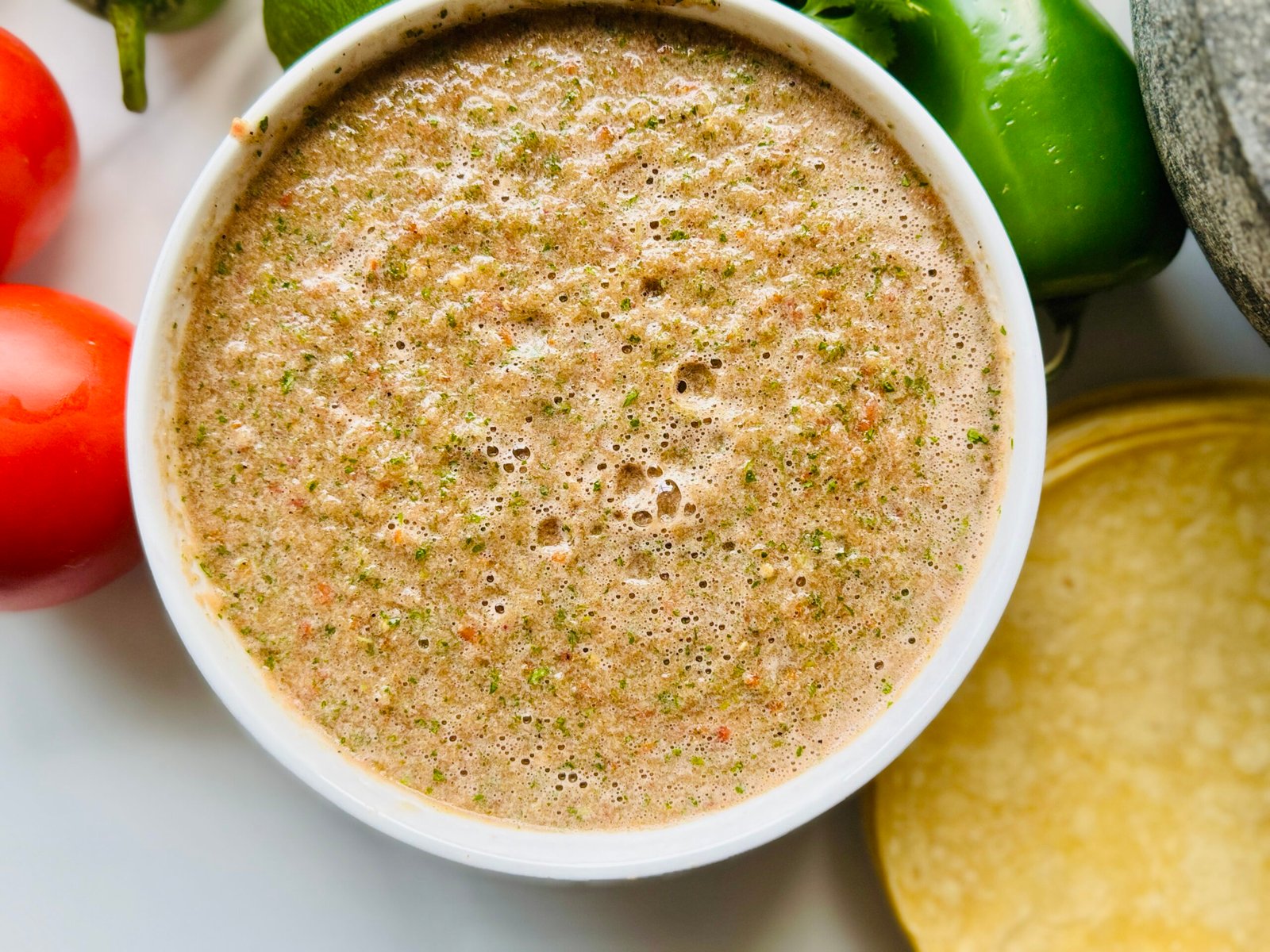 Blender salsa with fresh tomatoes jalapeño cilantro lime onion and honey blended into a loose red salsa