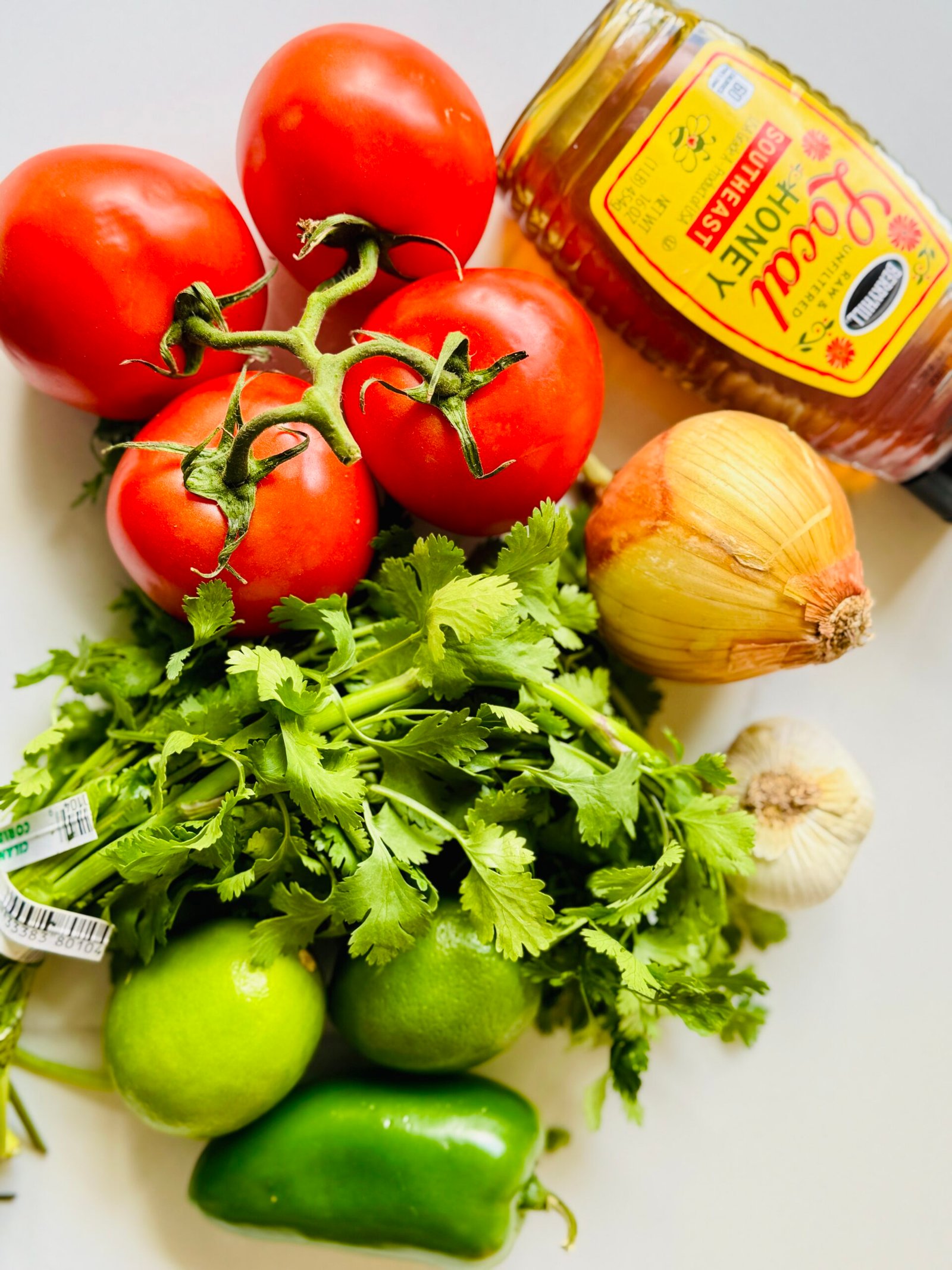 Ripe tomatoes jalapeño lime red onion cilantro honey and salt ready for fresh tomato salsa
