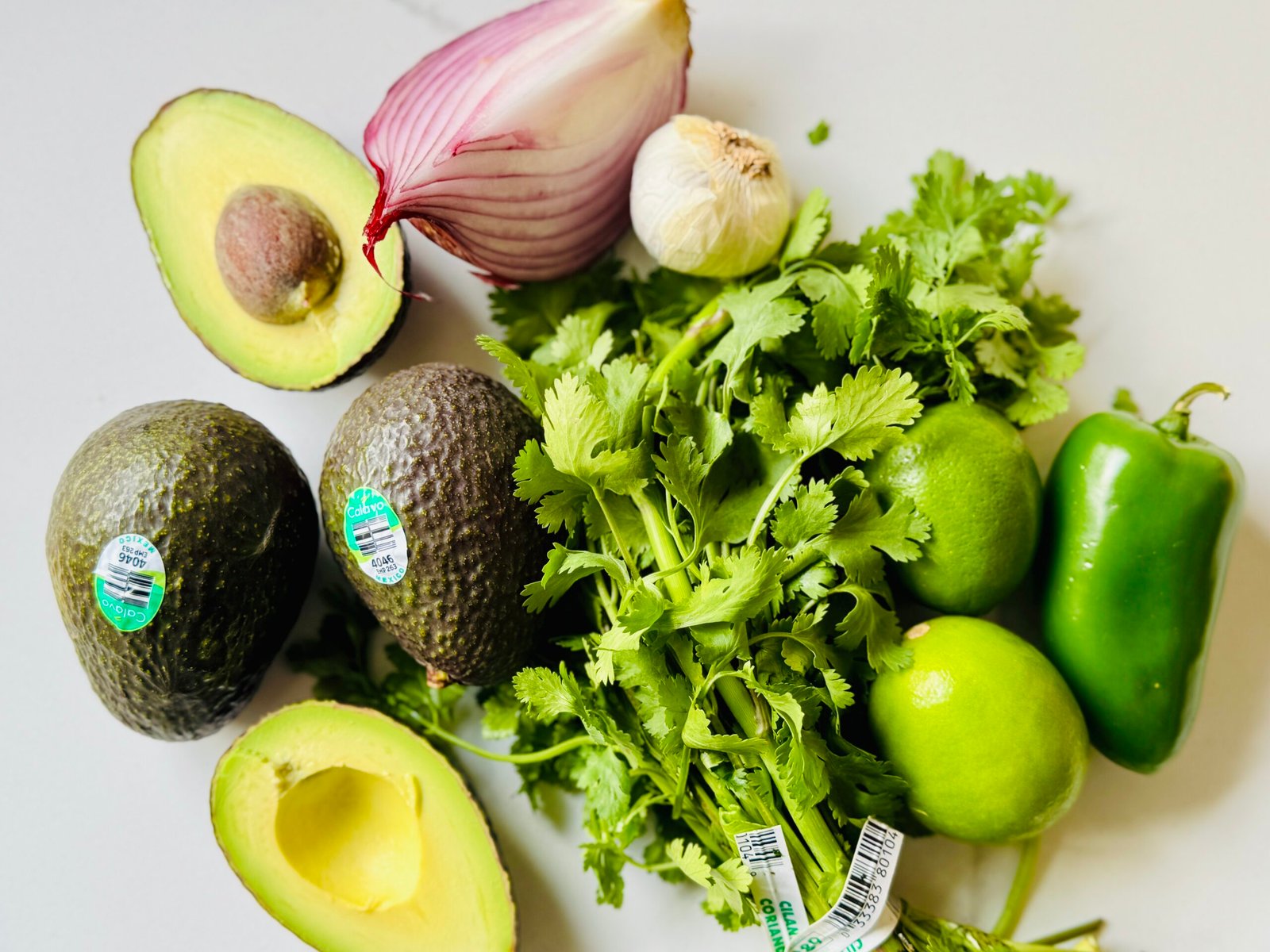 Ripe avocados lime jalapeño red onion cilantro garlic and salt ready for molcajete guacamole