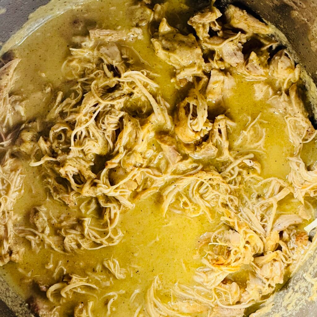 Shredded Instant Pot mojo chicken coated with reduced citrus garlic cooking juices