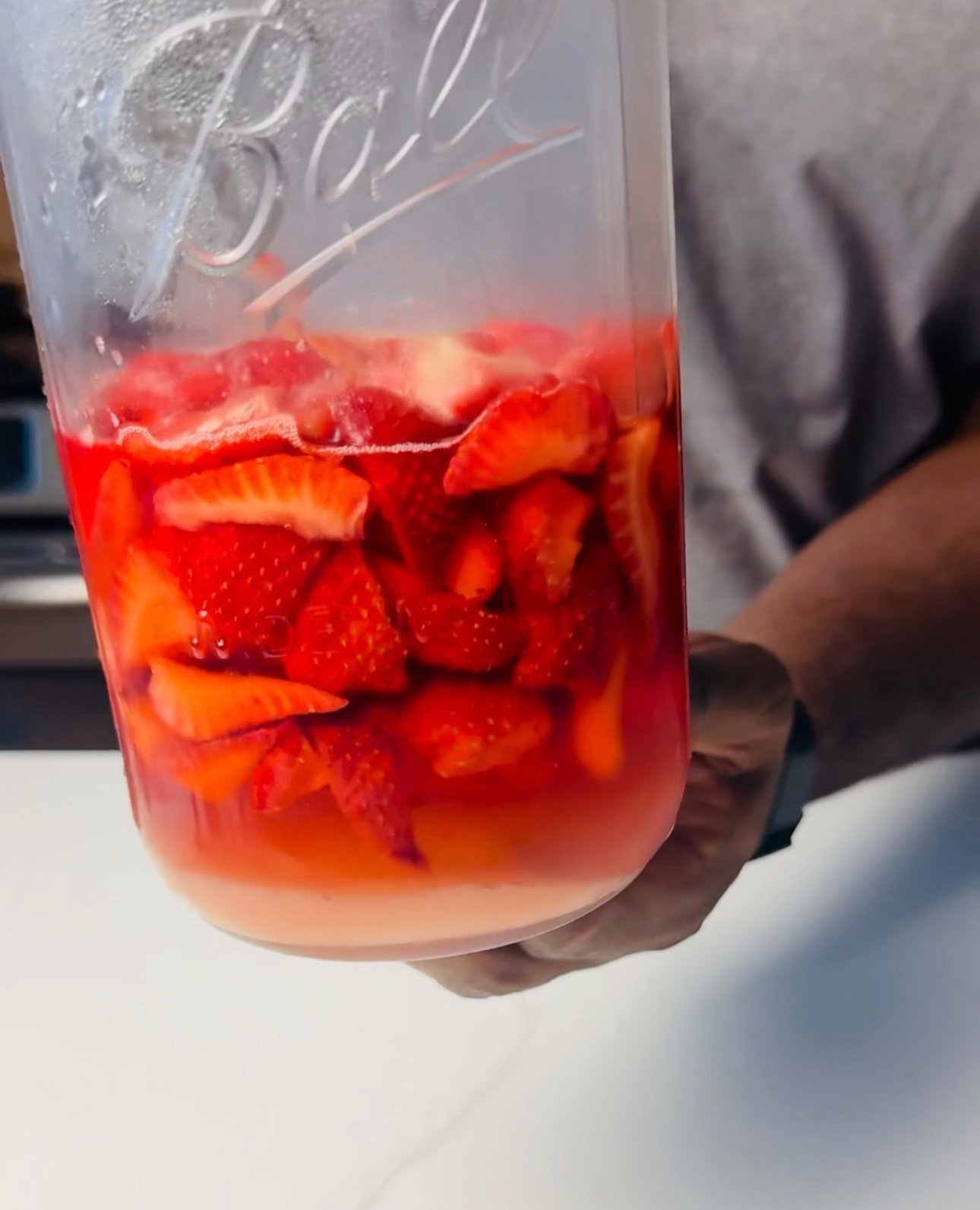 macerated strawberries in jar with strawberry syrup liquid