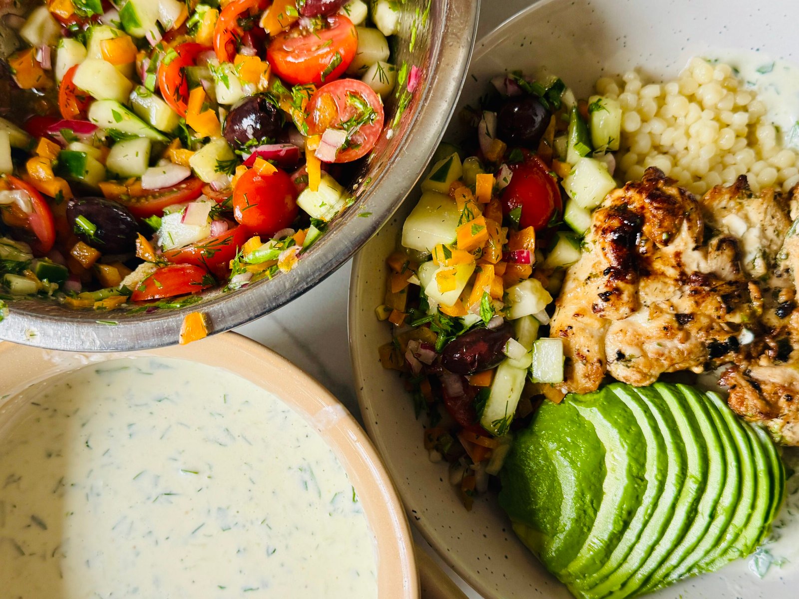Creamy Greek sauce sliced yogurt marinated chicken and couscous bowl