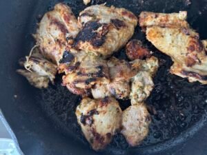 Greek yogurt marinated chicken thighs browned in a cast iron skillet