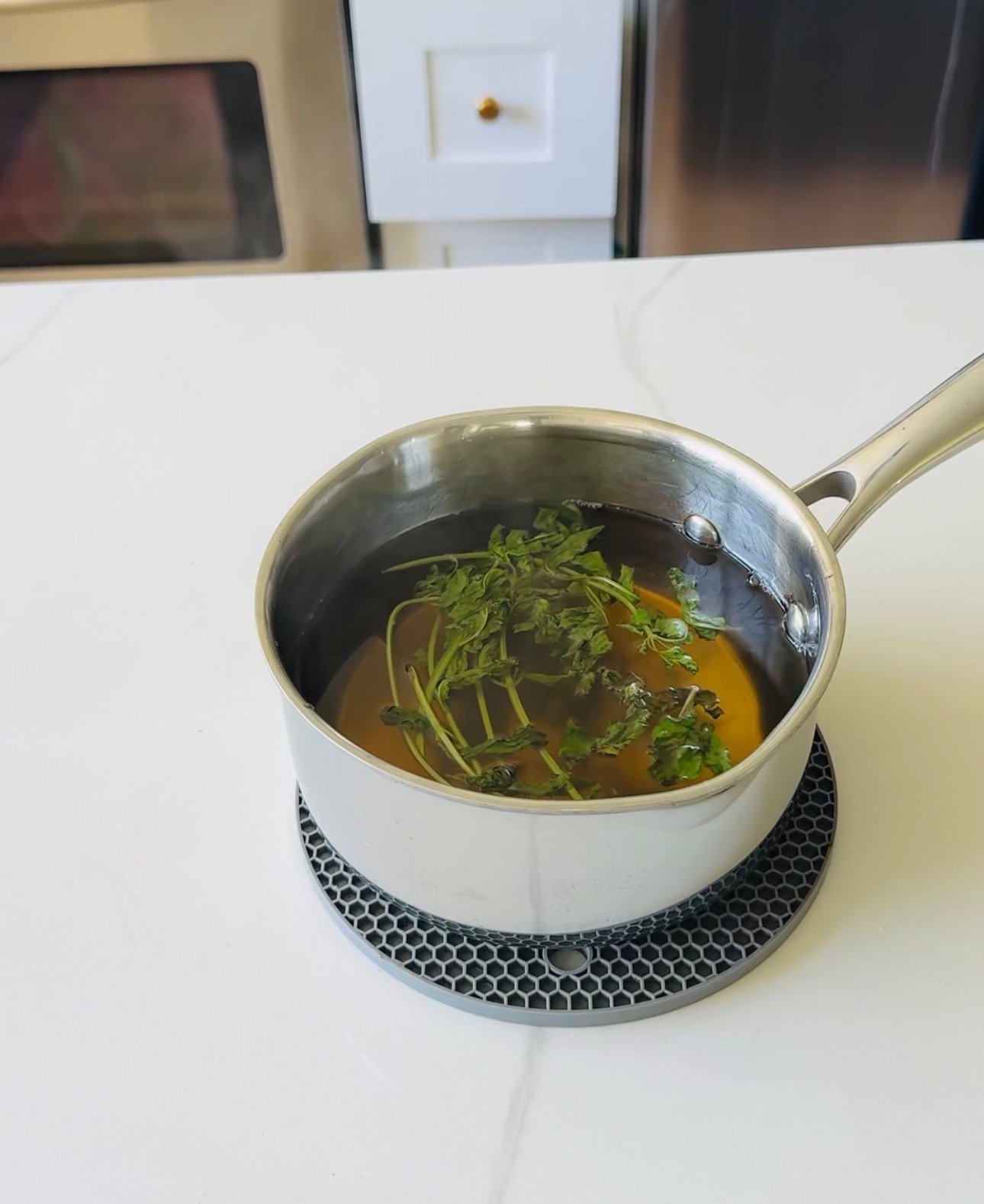 Fresh mint leaves steeping in warm simple syrup for homemade mint syrup