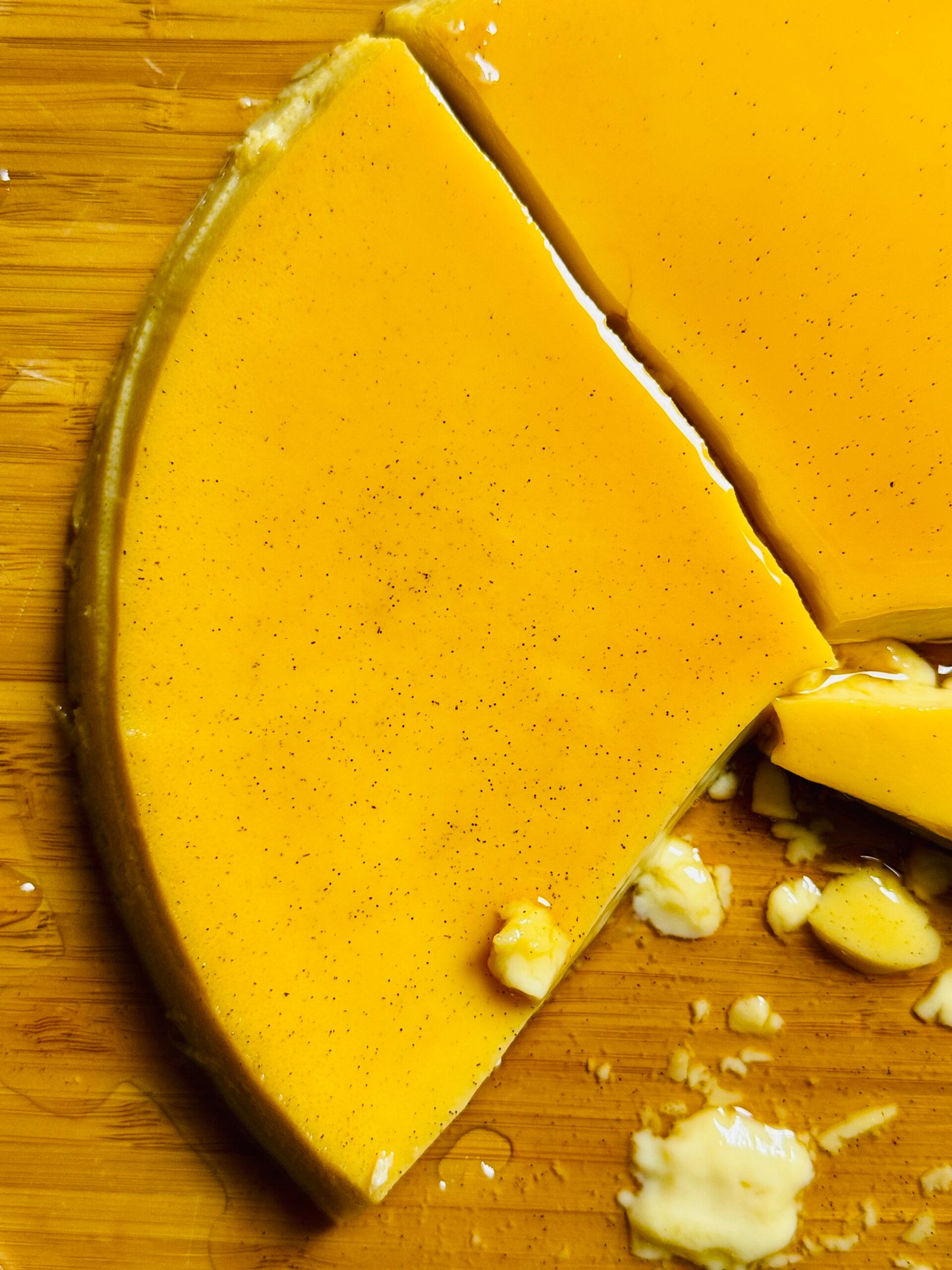 Close-up of a slice cut from extra creamy caramel flan showing its silky texture.