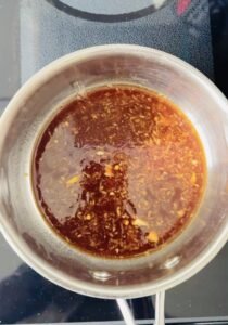 Clean reserved soy ginger marinade simmering separately into a glaze in a saucepan