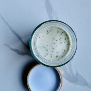 Greek yogurt chicken marinade with lemon, garlic, oregano, cumin, and olive oil in a glass jar
