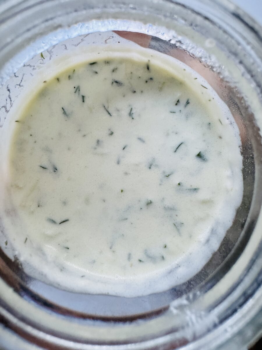 Close view of creamy Greek yogurt marinade speckled with oregano, cumin, lemon, and garlic
