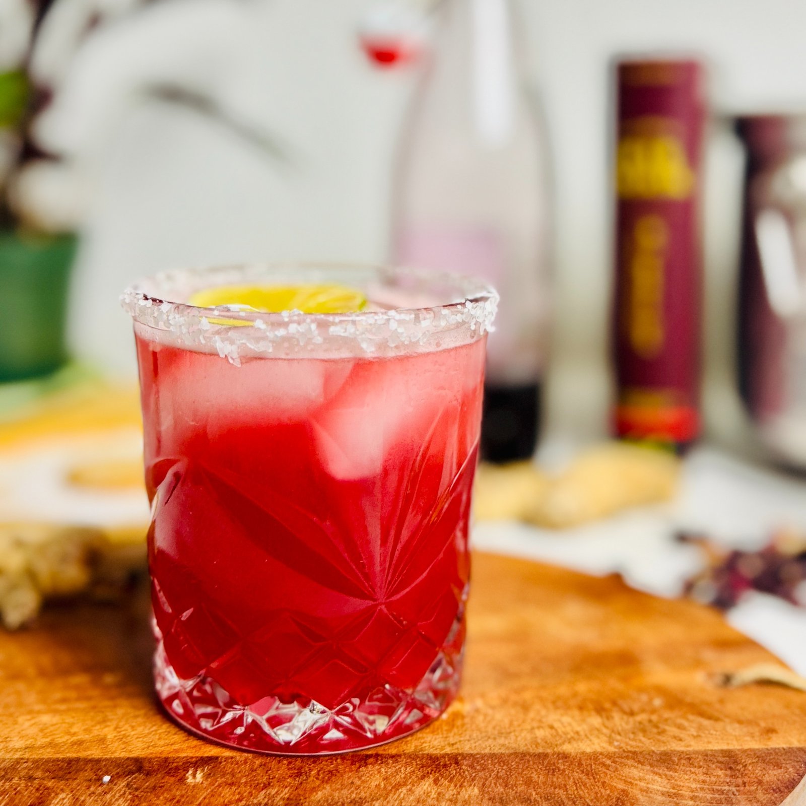 Red hibiscus-ginger beer Paloma over ice in a salt-rimmed glass.