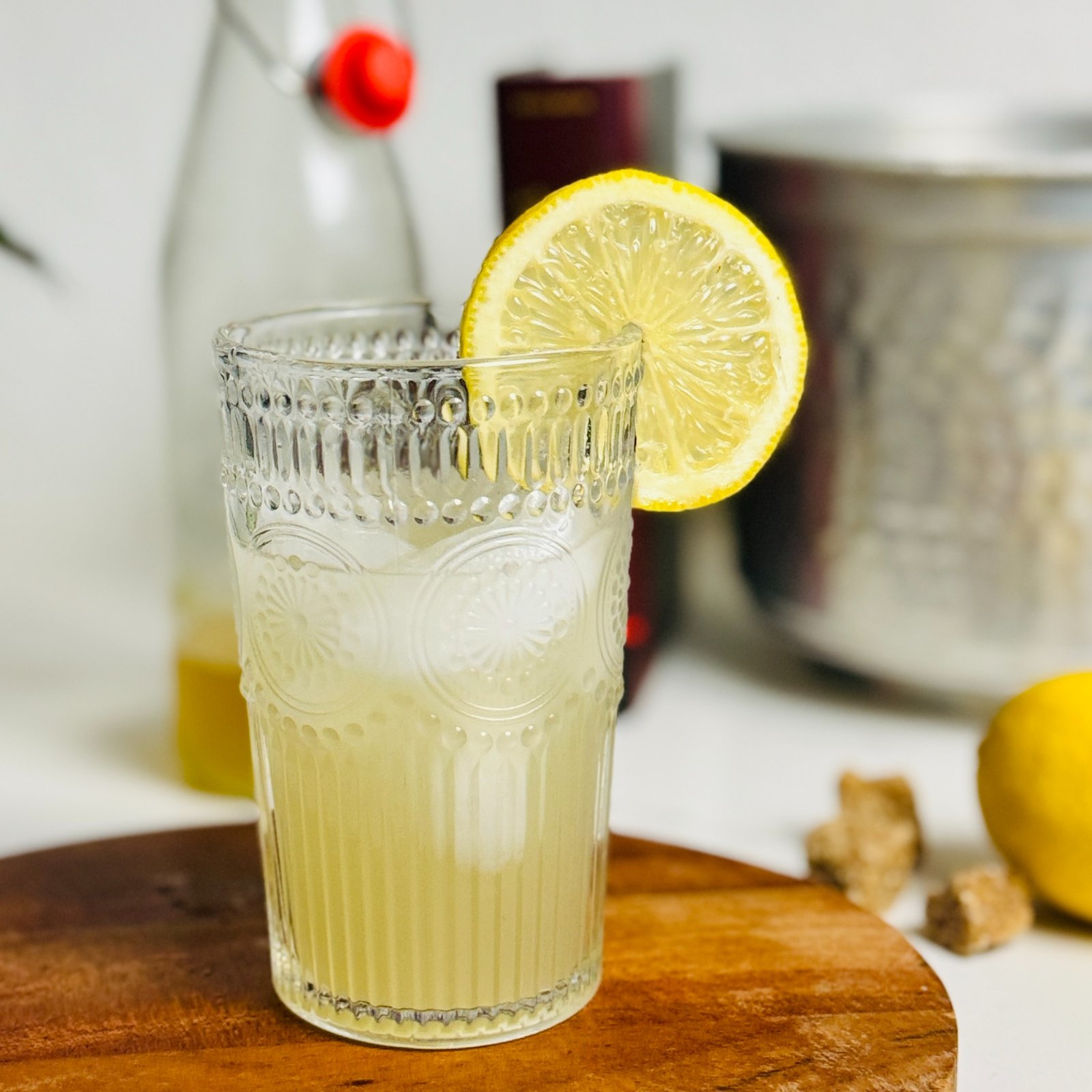 Lemon oleo lemonade over ice in a tall glass with a lemon wheel.