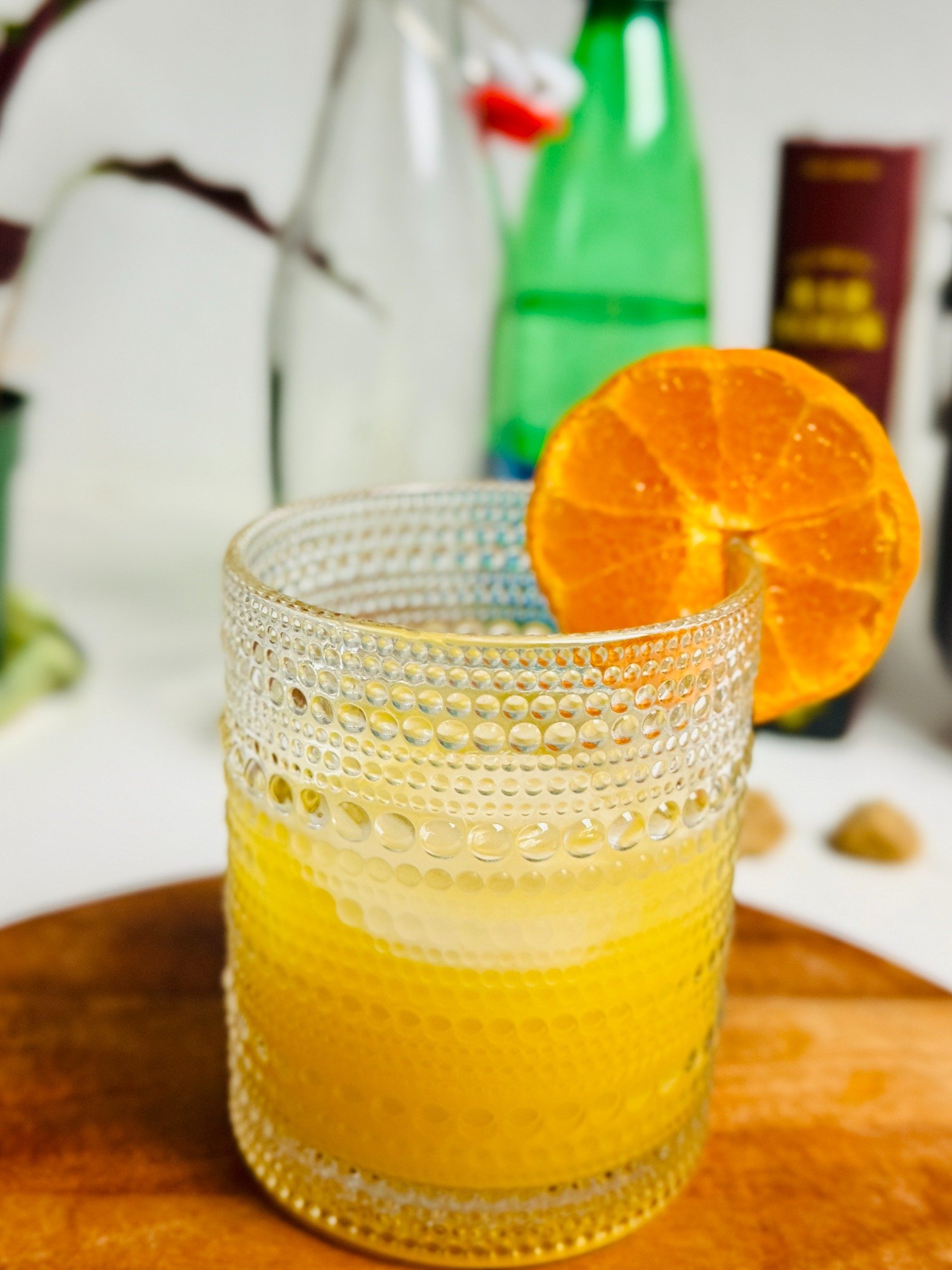 Orange-vanilla creamsicle spritz over ice with an orange wheel in a textured glass.