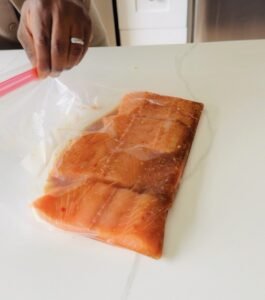 Salmon fillets marinating in soy ginger sauce inside a zip-top bag