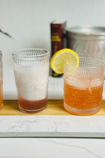 Four strawberry syrup drinks: lemonade, Italian cream soda, gin Collins, and a salt-rimmed margarita.
