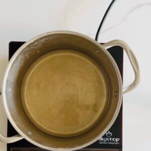 White wine warming in a pot during the first stage of making cheese fondue.
